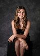 Beautiful confident tween girl with long hair in a black sparkly dress