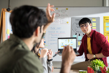 Asian man creative designers present ux ui to team.Designers team working meeting in a modern office.