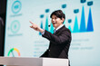 Asian Businessman Stands on Stage for Business Presentation