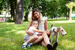 © iordani - young pretty caucasian mother walking with little cute daughter and dog fox terrier, lifestyle people concept