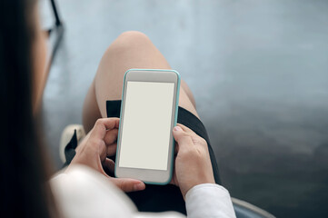 Wall Mural - Closeup shot of woman hand holding blank screen smartphone.