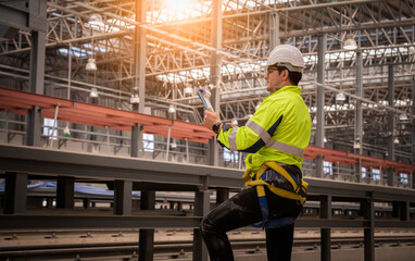 Wall Mural - Engineer under inspection and checking construction process railway and checking work on railroad station .Engineer wearing safety uniform and safety helmet in work.