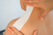 © familylifestyle - Physiotherapist chiropractor doctor is applying kinesio tape to woman patient's back and neck. Use of tapes in medicine for fixation of muscles and joints. Recovery rehabilitation after an injury.