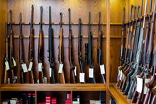 Gun Shop Interior With Hunting And Sporting Rifles Standing In Row On Display Stand