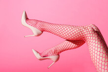 Female Legs Raised In Sexy Pink Fishnets And High Heels