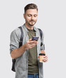 © kite_rin - Handsome young man looking at smart phone and holding coffee cup isolated studio portrait, Smiling student men going on travel, technology, student lifestyle, connection concept.