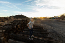 7 Year Old Boy Standing Alone On Railroad Ties At Sunset