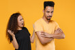 © ViDi Studio - Young couple friends together family african indignant angry woman man 20s in black tshirt scream shout arguing with boyfriend hands folded crossed isolated on yellow color background studio portrait