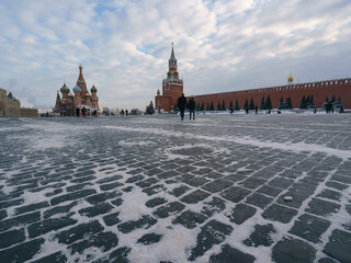 Wall Mural - Photography of Moscow downtown, Red Square at winter day. Bright Saint Basil's Cathedral (Cathedral of Vasily the Blessed), Spasskaya Tower.  Blue sky had been covered by white clouds