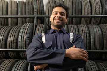 Wall Mural - Portrait of happy technician at a tyre shop	