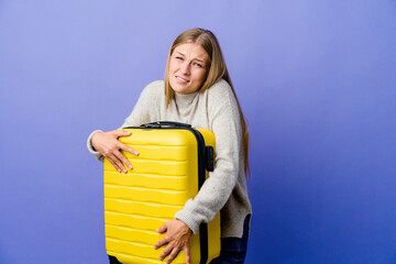 Wall Mural - Young russian woman holding suitcase to travel going cold due to low temperature or a sickness.