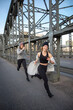 Junge Frauen laufen gutgelaunt über Brücke