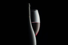 Elegant Red Wine Glass And A Wine Bottles In Black Background