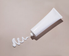 Cosmetic Cream Tube And Stroke On Beige Background