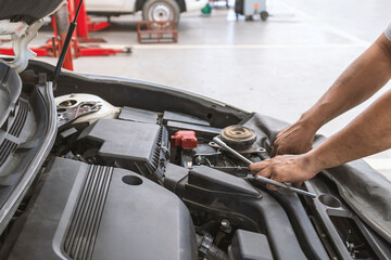 mechanic working car maintenance with soft-focus and over light in the background