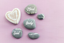 Zen Stones With The Words Mind Body Soul. Purple Wooden Background