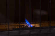 Small Pilot Flame For Gas Furnace Heater.  Constant Blue Flame For Igniting Main Burners, Behind Safety Grill.  Room For Copy.