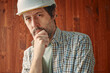 Portrait of thoughtful male worker with white protective helmet, employment and labor concept