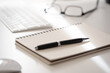 © Christian Horz - close-up of spiral notepad with ballpoint pen on white office desk, taking notes concept
