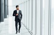 A modern bearded Indian man walks down the corridor of a modern building, a busy businessman goes to a business meeting
