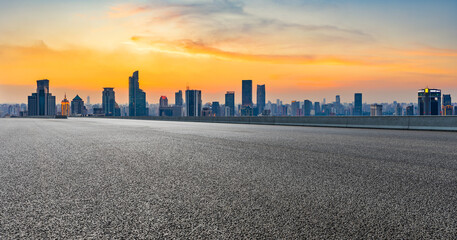 Empty asphalt road and city skyline with buildings at sunset in Shanghai.