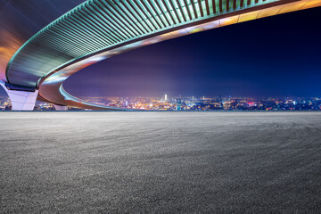 Race track road and bridge with city skyline at night in Shanghai.