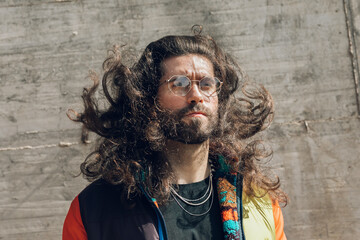 young man with long hair wearing glasses outdoors