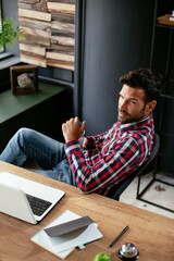 Wall Mural - Young businessman working in his office. Thirsty businessman drinking water..