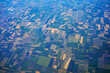 Daytime view from a flying plane over fields and land shares