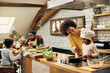 © Drazen - Happy black mother enjoying in preparing food with her small daughter at home.