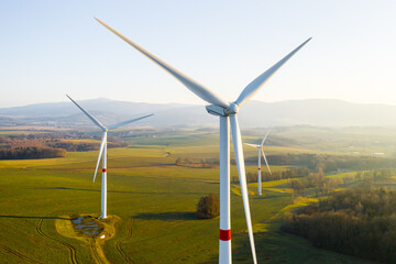 Panoramic view of wind farm or wind park, with high wind turbines for generation electricity with copy space. Green energy concept.