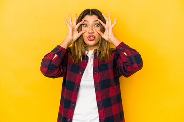 Wall Mural - Young indian woman isolated on yellow background keeping eyes opened to find a success opportunity.