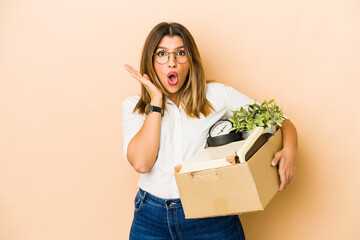 Wall Mural - Young indian woman moving holding a box isolated surprised and shocked.