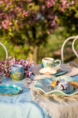 Breakfast, lunch, dinner in the flowery garden. Tea party in the blooming garden. Breakfast in the garden in nature. Outdoor tea table english vintage style in garden