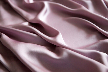 Beautiful smooth elegant wavy pink satin silk luxury fabric. Copy the background texture of the space pink silk fabric.