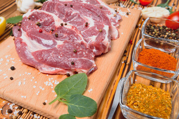 Wall Mural - Raw pork meat with spices and vegetables on wooden table