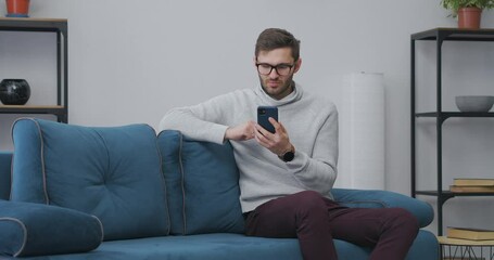 male user is playing lottery in app or internet site in smartphone and winning, emotional rejoicing of winner
