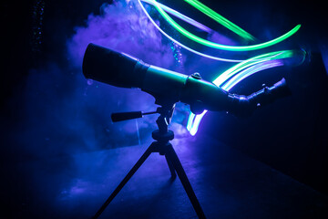 Wall Mural - silhouette of a astronomy telescope on dark foggy backlight.