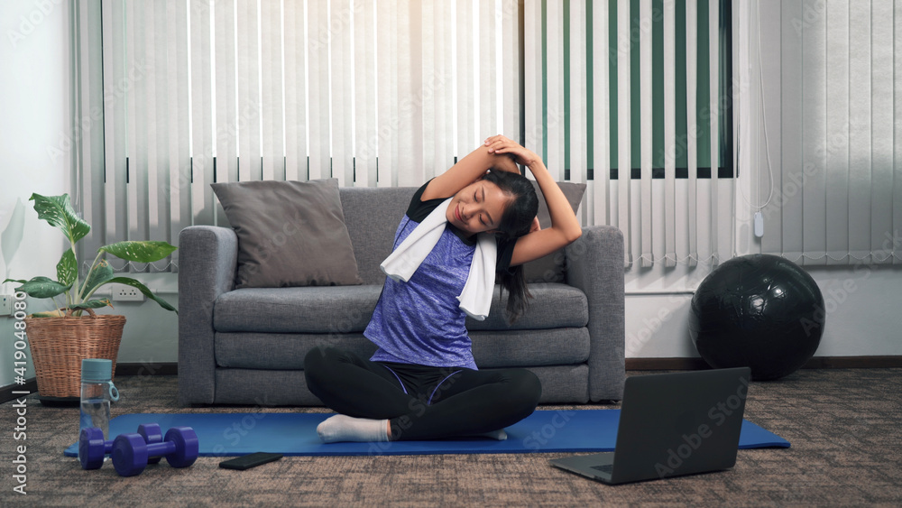 Asian woman stretching during a yoga class with a trainer at her laptop computer at home. - obrazy, fototapety, plakaty 
