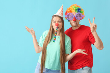 Poster - Young couple in funny disguise on color background. April Fools Day celebration