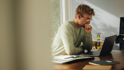 man looking at laptop and thinking