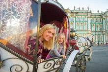 A Girl With A Child In An Old Carriage On Palace Square In St. Petersburg