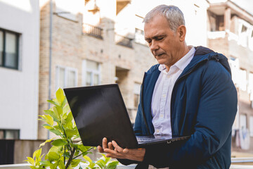 Wall Mural - attractive senior man using laptop