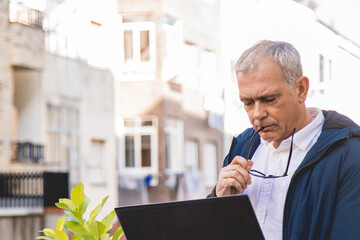 Wall Mural - adult  man with glasses using laptop