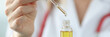 Doctor dripping cosmetic oil from pipette closeup