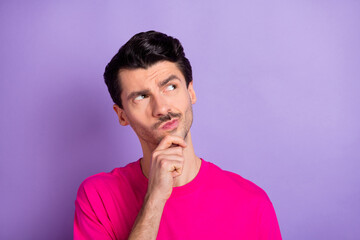 Photo of young serious thoughtful minded man thinking hold hand chin looking copyspace isolated on violet color background