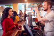 Smiling Male Bartender Behind Counter Serving Female Customer With Beer
