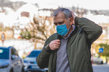 Wall Mural - casual adult man with medical mask protecting from coronavirus around the city