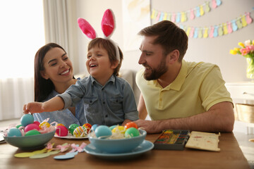 Poster - Happy family painting Easter eggs at table indoors