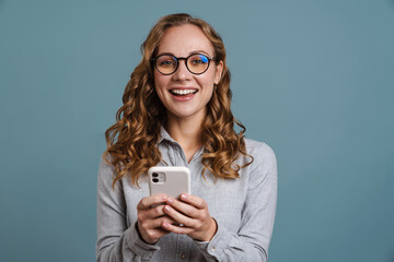 Cheerful young girl usig mobile phone isolated